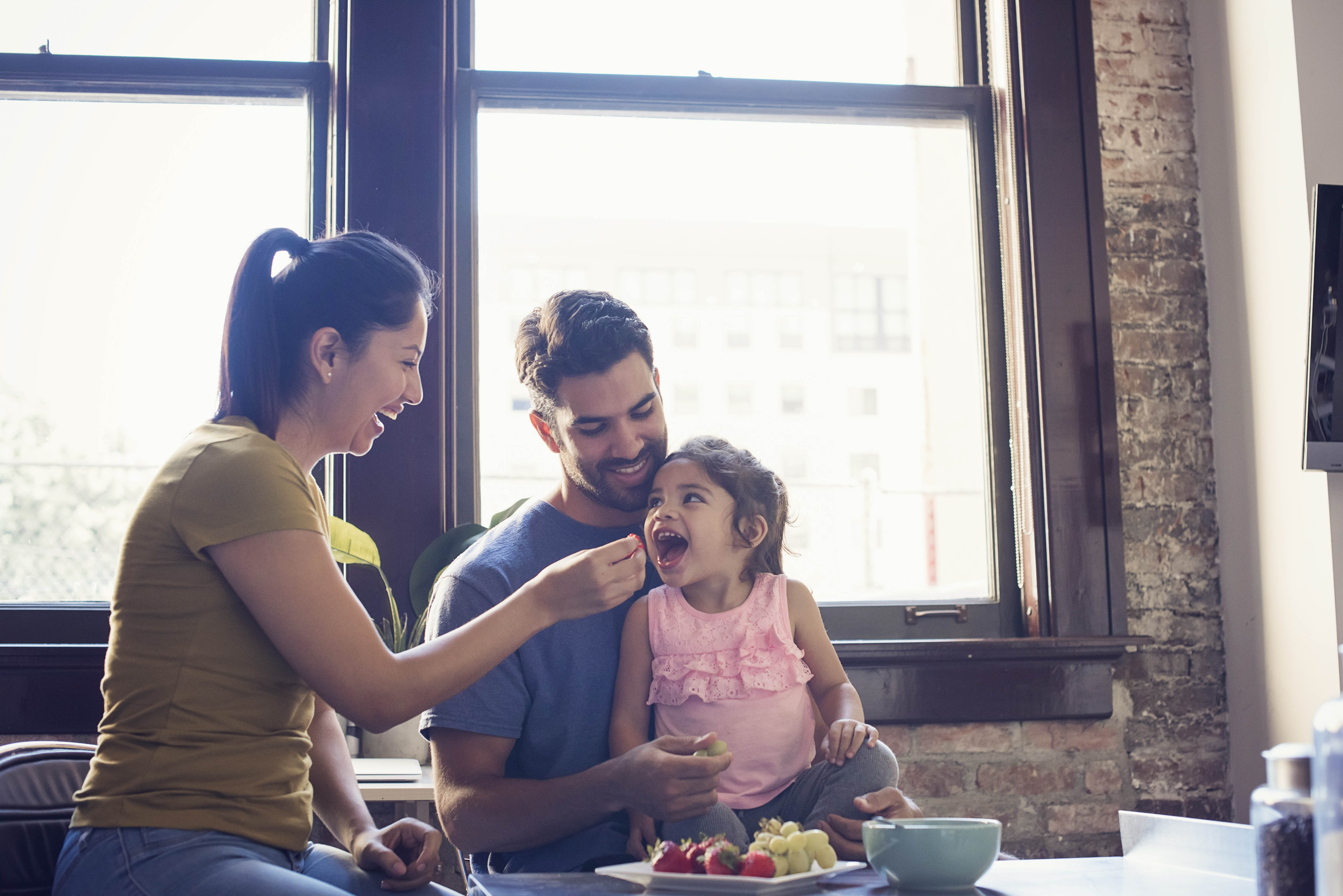 young family feeding toddler